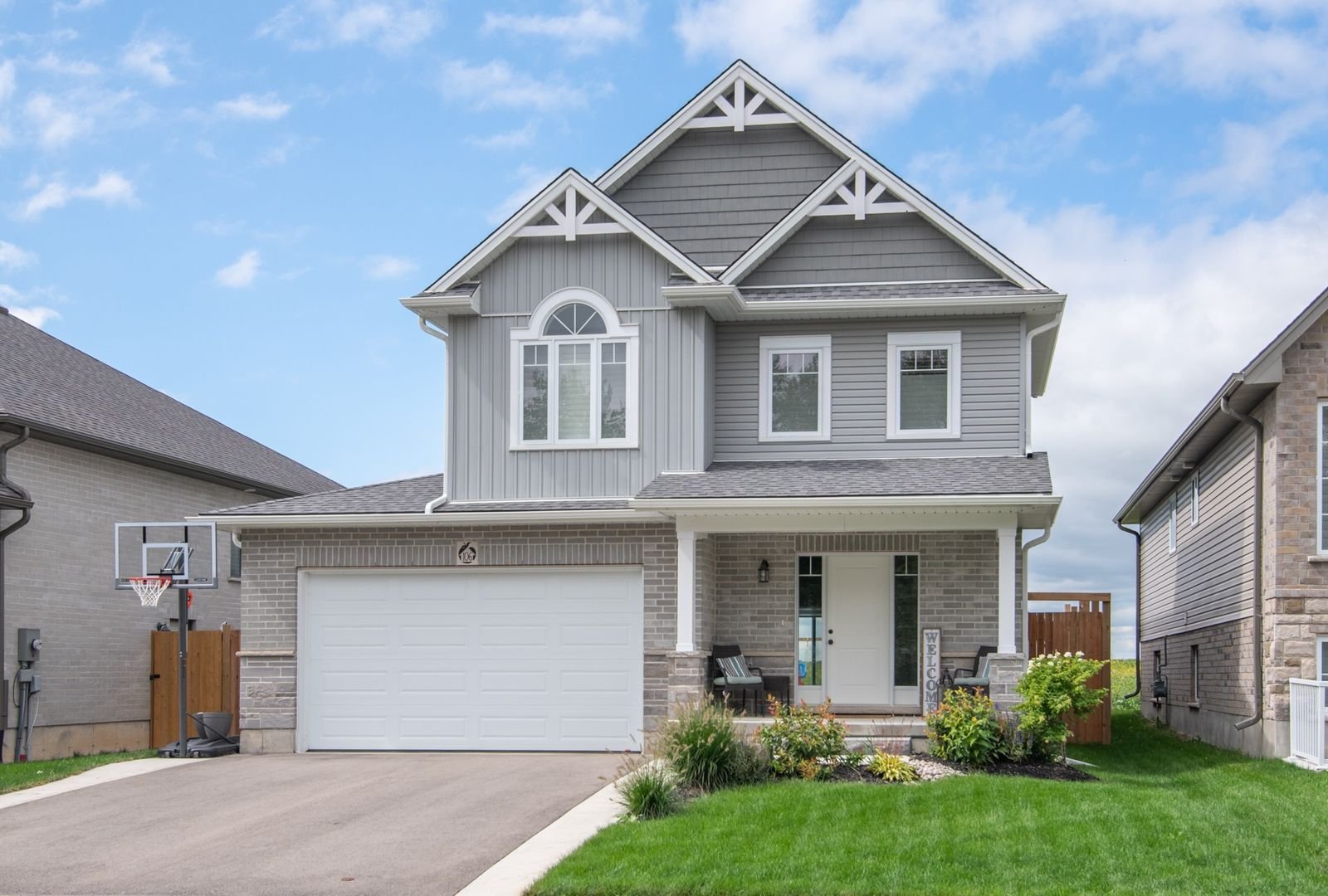 Two-storey home with grey siding and board and batten gable