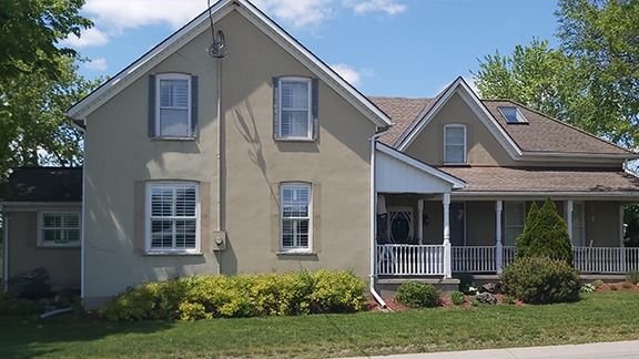 Two-storey home with stucco and siding and a wraparound porch